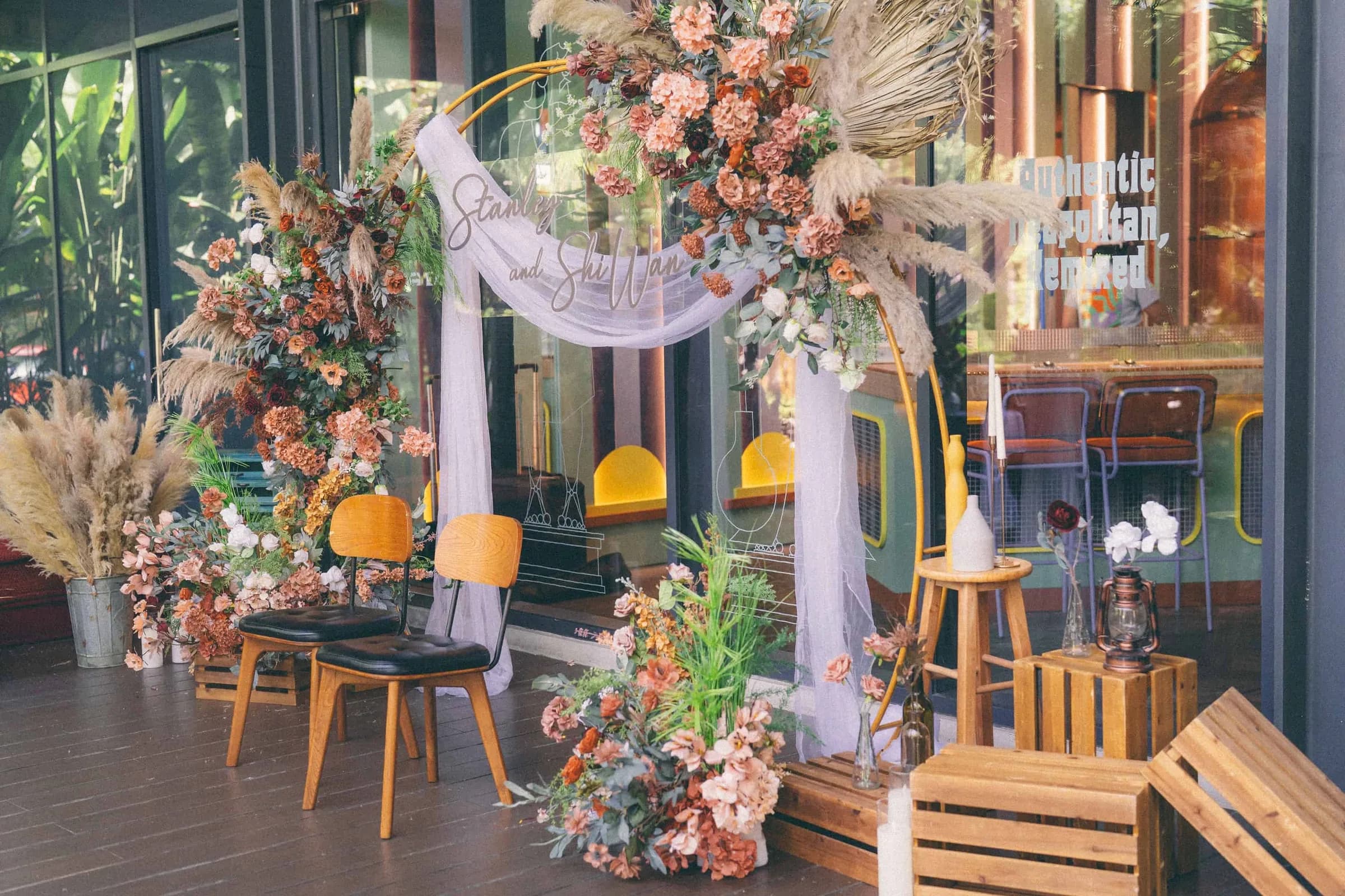 Traditional wedding tea ceremony area with wooden chair seating for two and botanical arrangements