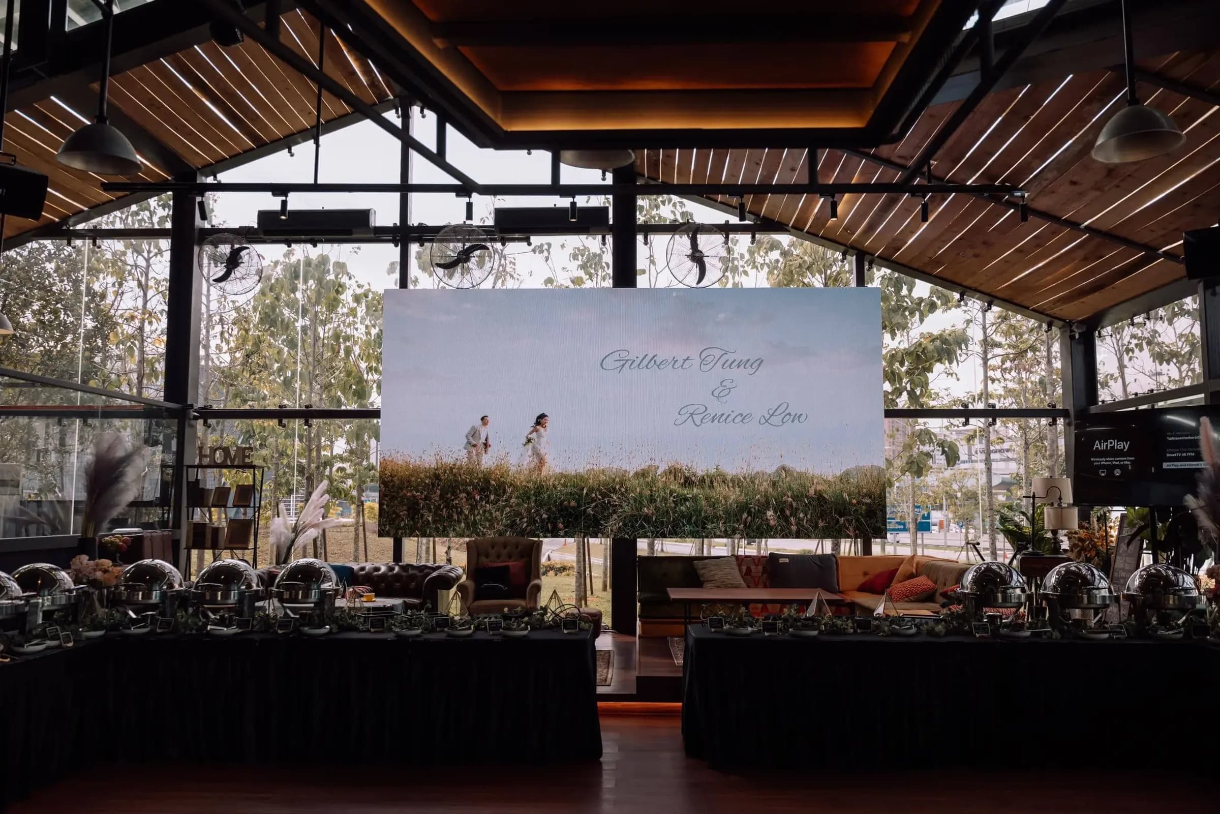 Event venue setup with LED screen and decorated dining tables